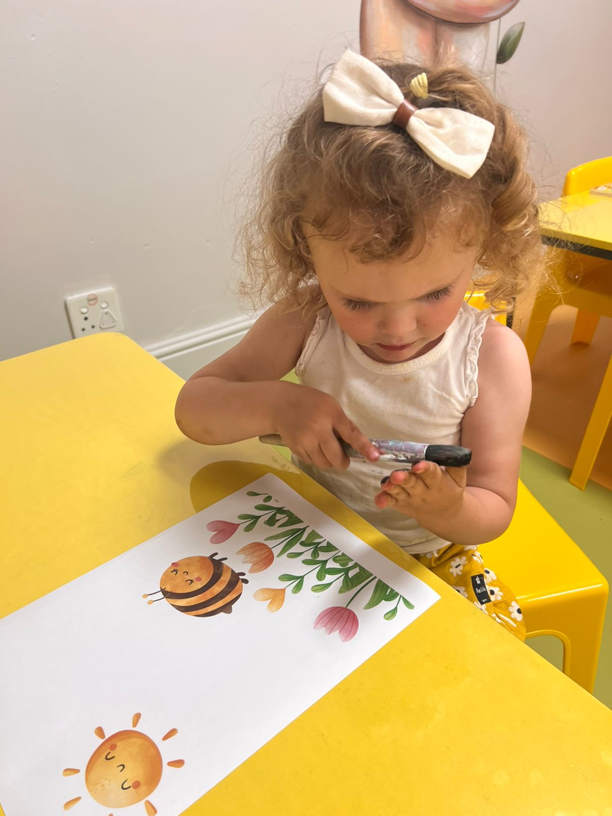 A child painting bees and flowers