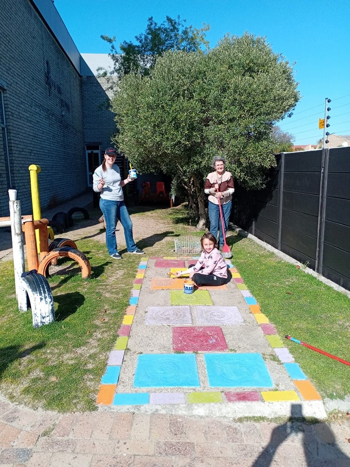 Children painting the outdoor hopscotch path