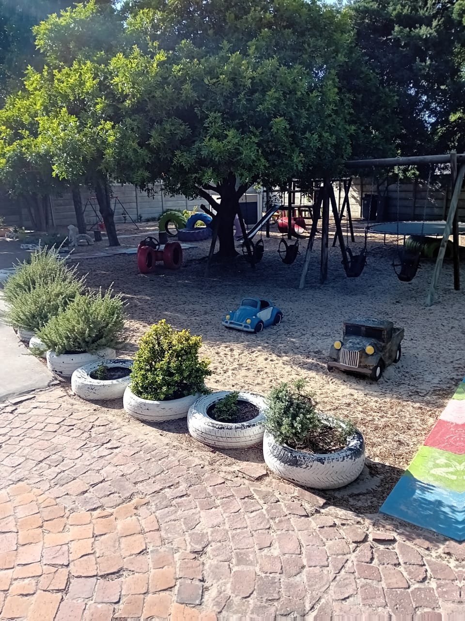Outdoor playground with classic VW Beetle ride-on under the trees