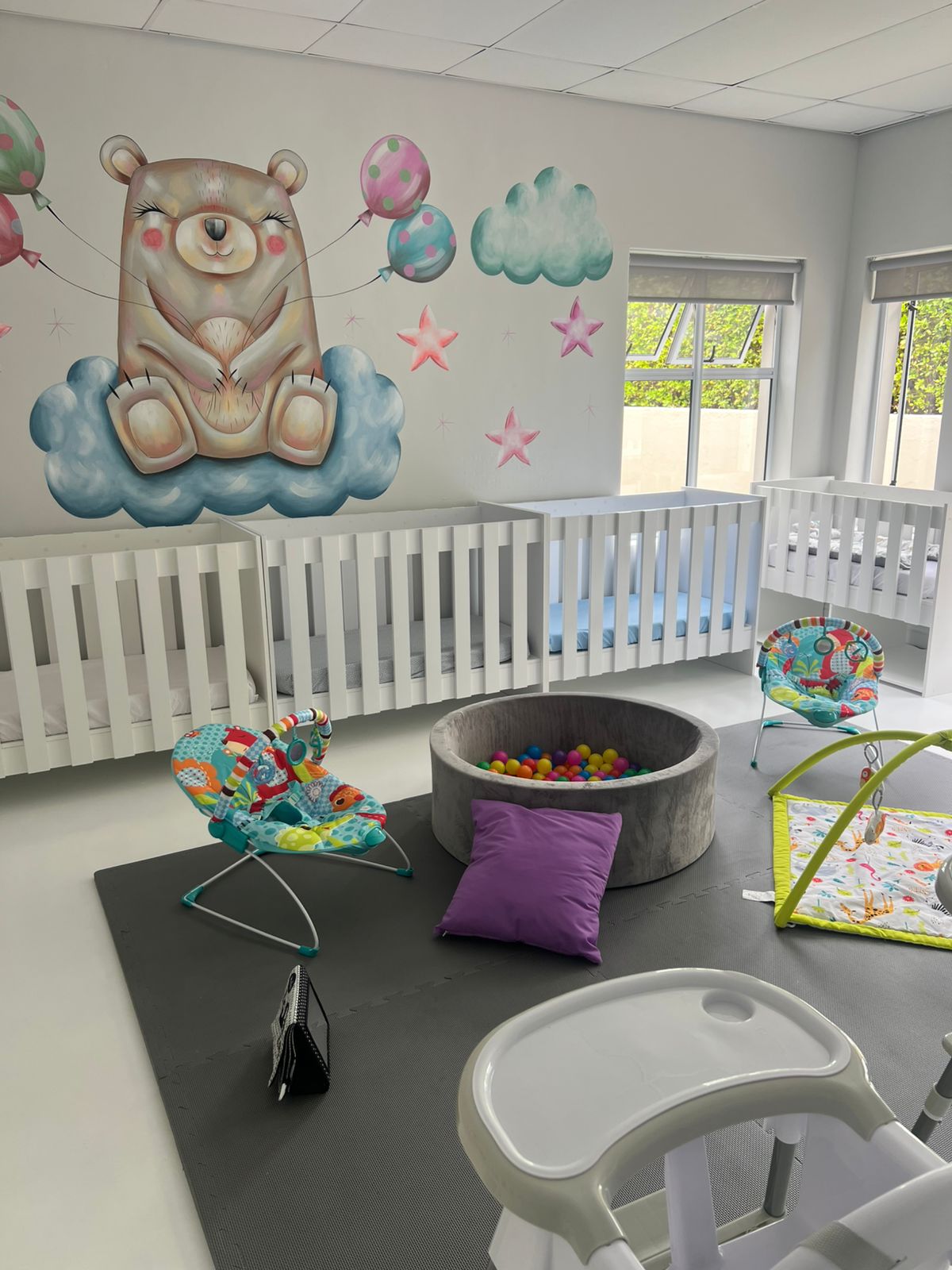 Sunny activity room with a bunny mural and yellow tables
