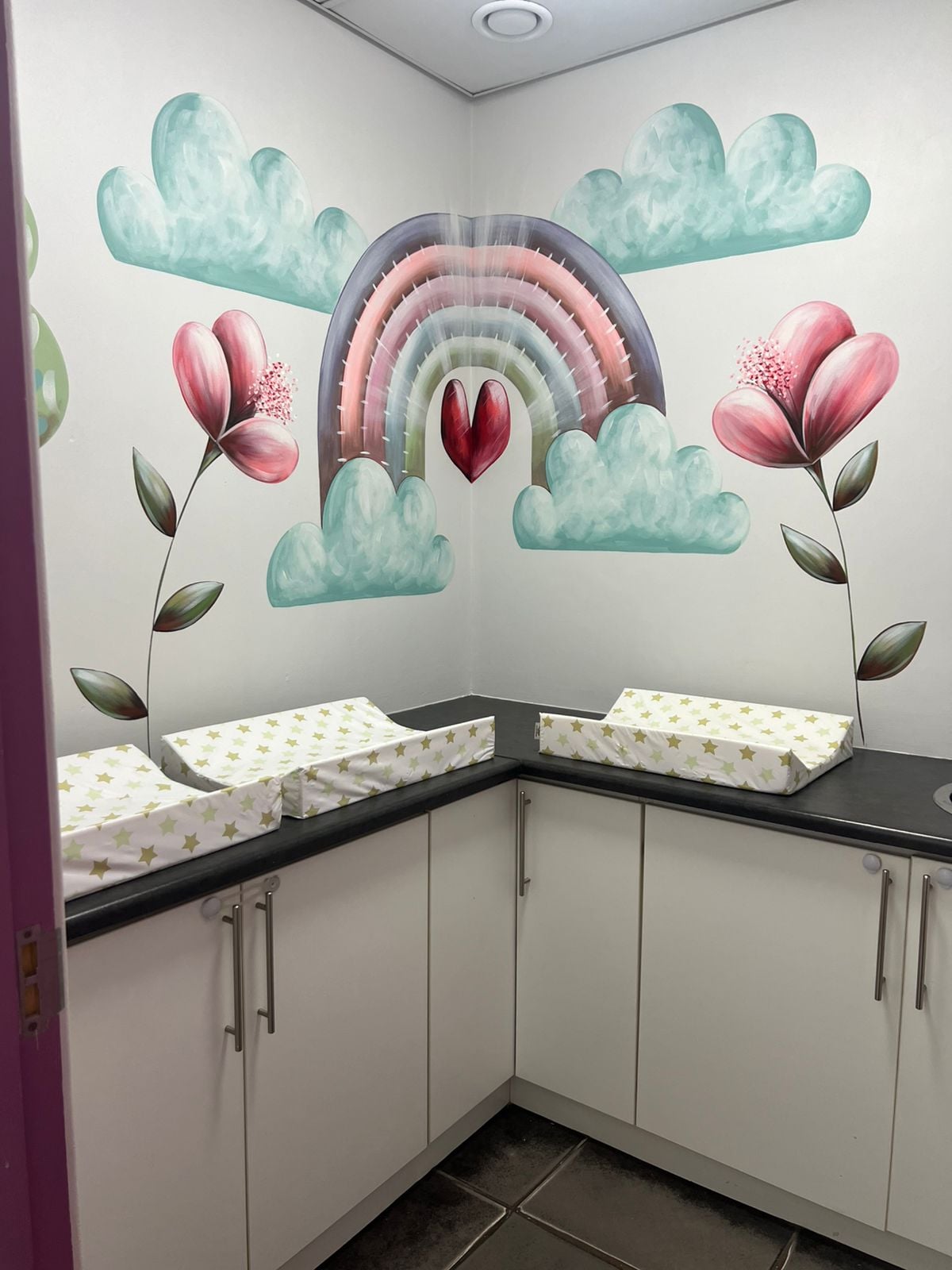 Calm infant nursery with cribs and bear mural